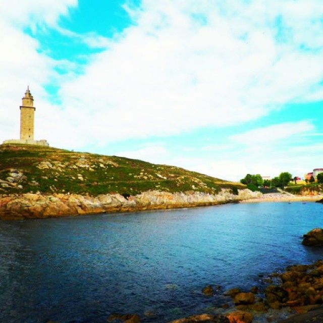 water, sky, tranquil scene, tranquility, scenics, cloud - sky, beauty in nature, built structure, lighthouse, nature, sea, cloud, blue, architecture, building exterior, lake, river, idyllic, tree, rock - object