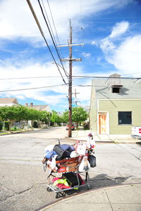 Luggage and fabrics in shopping cart on street