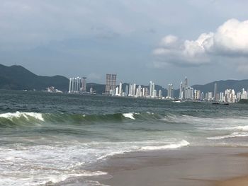 Sea and cityscape against sky