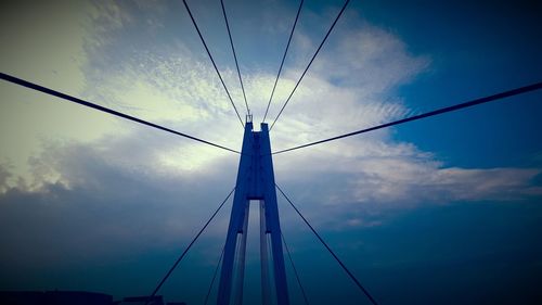 Low angle view of electricity pylon against blue sky
