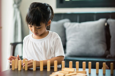 Girl playing with toy blocks on table