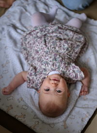 High angle view of little baby girl lying on the sofa