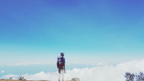 Low angle view of man against blue sky