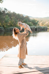 Smiling young mother playing with baby boy 1 year old wear casual clothes over nature background