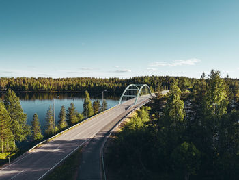 Empty road by lake against sky