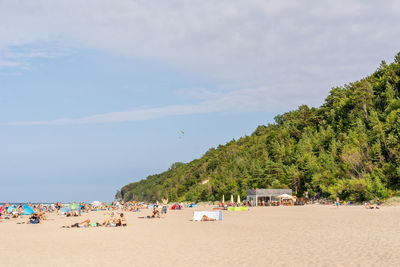 Group of people on beach against sky