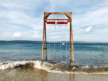 Lifeguard hut on beach against sky