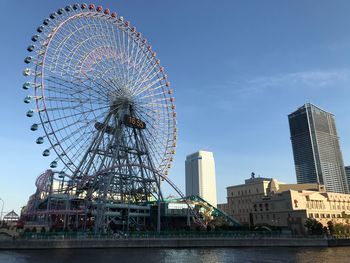 Low angle view of ferris wheel against buildings