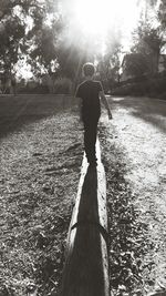 Rear view of woman walking on grassy field