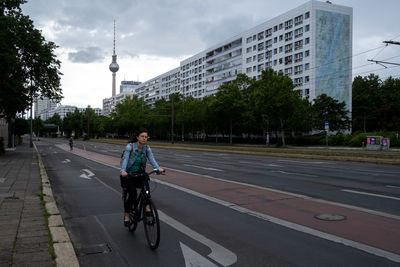 Man riding bicycle on road in city