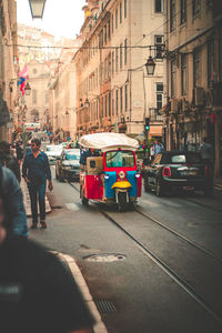 Vehicles on road amidst buildings in city