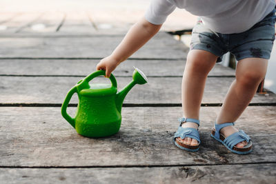 Low section of boy playing with umbrella