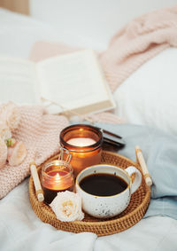 Romantic breakfast in bed. hygge concept. tray of coffee and candles on bed.