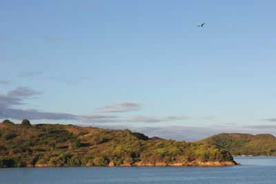 Scenic view of sea and mountains against sky