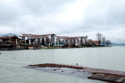 Scenic view of river by buildings against sky