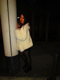 Portrait of young woman looking at camera during winter at night