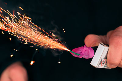 Low angle view of hand holding fireworks at night