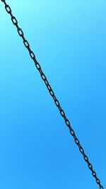 Low angle view of chain against clear sky