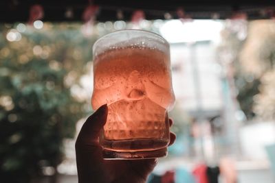 Close-up of hand holding beer glass