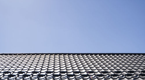 Low angle view of roof tiles against sky