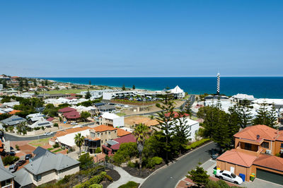 High angle view of buildings by sea against blue sky