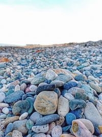 Stones on rocks at beach against sky