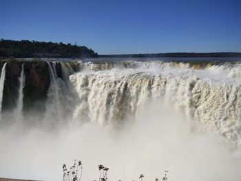 Scenic view of waterfall against sky