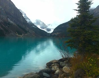 Scenic view of lake by mountains against sky