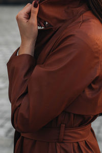 Fashion details of autumn long brown leather trench coat. street style casual clothing. 