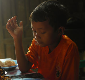 Close-up of boy eating food at home