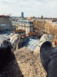 Low section of man in city against sky