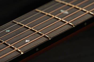 Close-up of guitar against black background