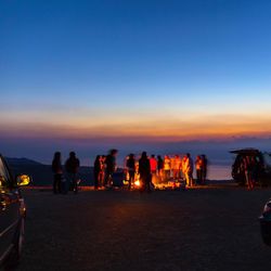 Friends around a bonfire during a late evening sunset at the dead sea, jordan 