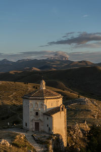 Buildings against sky with mountain in background