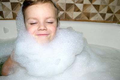 Happy little baby boy face swimming in the bathroom