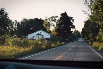 Road amidst trees against clear sky