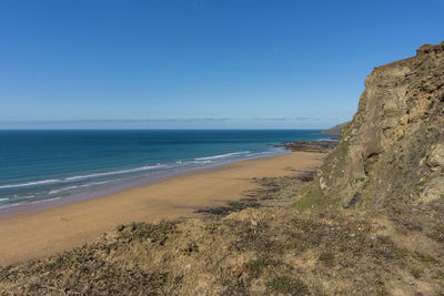 Scenic view of beach against clear blue sky