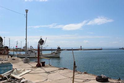 Boats moored at harbor against sky