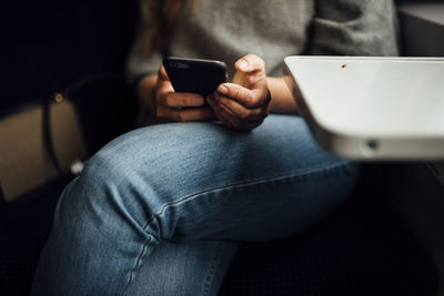 Midsection of man using mobile phone