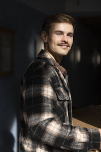 Side view of young man wearing flannel shirt at sunny day