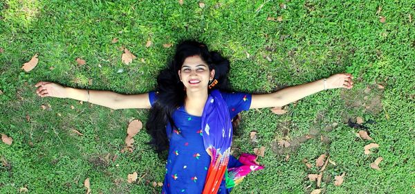 Portrait of young woman standing on field