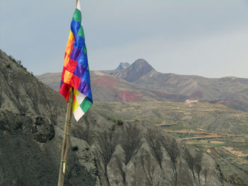 Low angle view of flags on mountain against sky