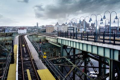 Railroad tracks in city against sky