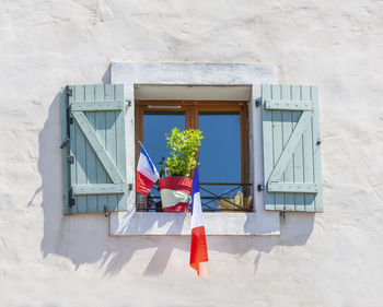 The facade of the building with the flags of france in the window.