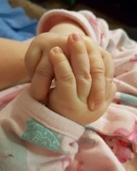 Close-up of baby hand on bed