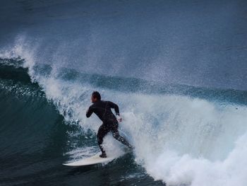 Man surfboarding in sea against sky