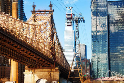 Low angle view of bridge against buildings in city