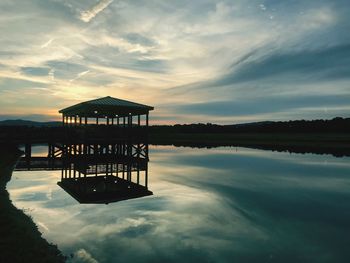 Silhouette pier on lake against sky during sunset