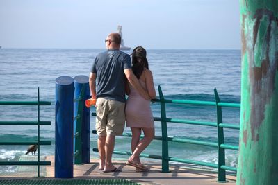 Rear view of couple looking at sea against sky