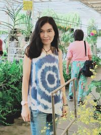 Happy woman standing against plants